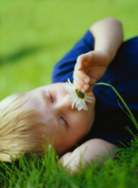 Boy smelling flower